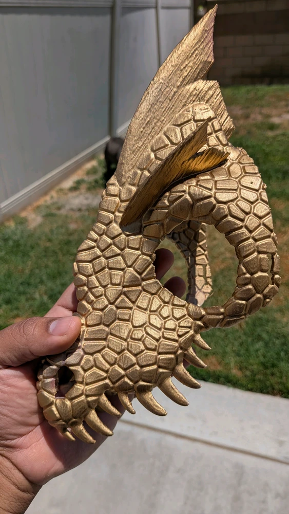 A dinosaur head painted gold.