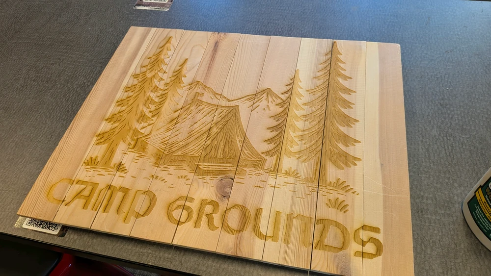 A wood carved sign that reads, "Camping Grounds."