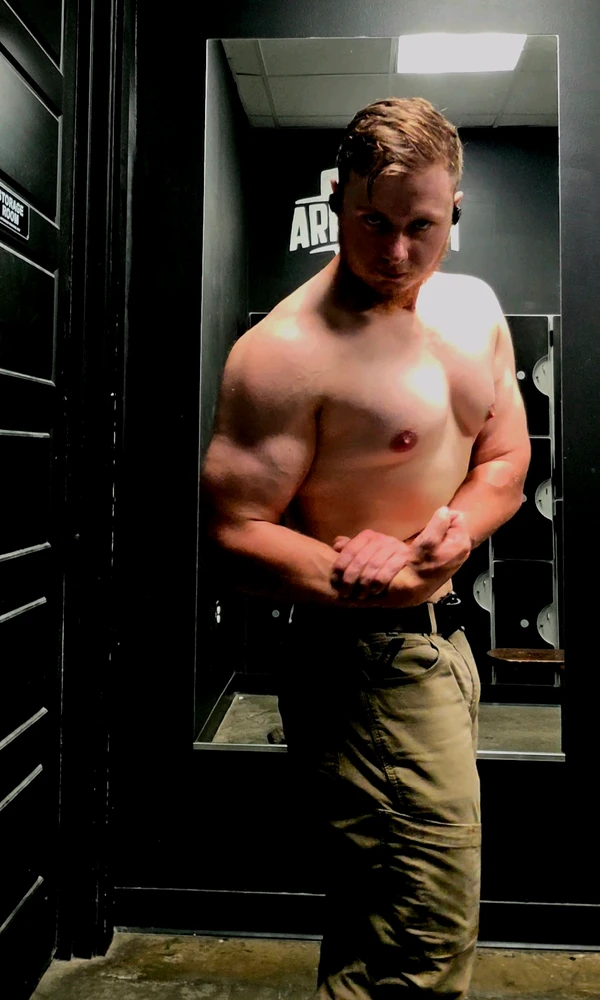 Joseph is doing a side chest and bicep pose.