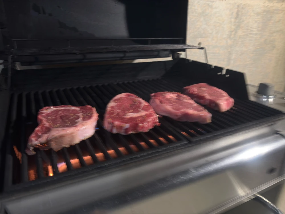Fresh red steaks on the grill, starting a nice sear on the grill fins.