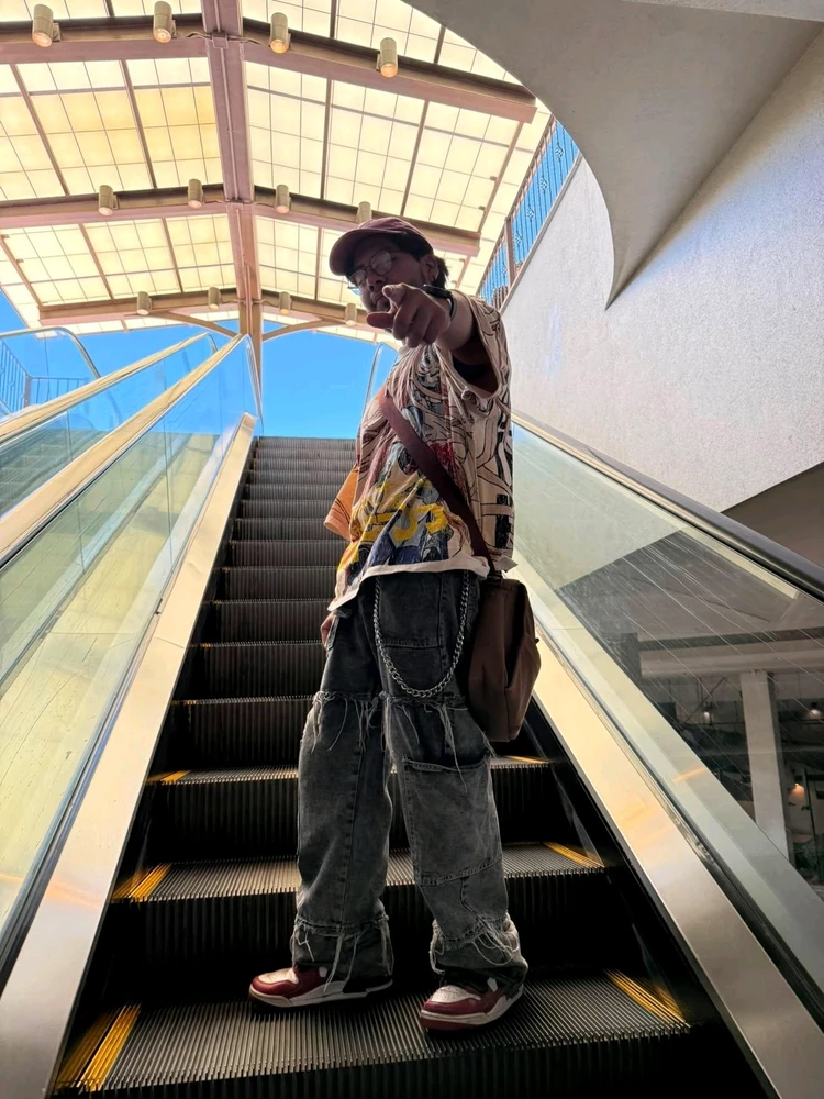 A person wearing y2k clothes in a escalator pointing 