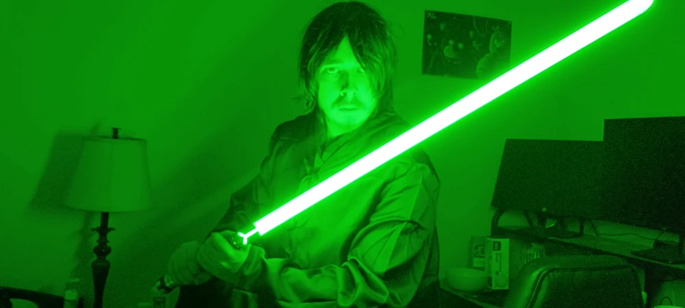 Jedi in black tunic and robes with a green lightsaber
