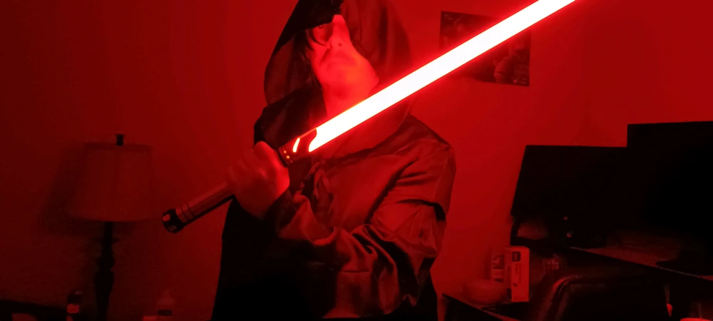 Sith in black tunic and robes with a red lightsaber
